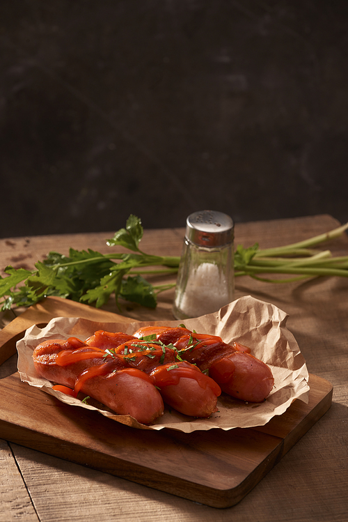 Grilled sausages with sauce ketchup on a wooden table