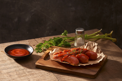 Grilled sausages with sauce ketchup on a wooden table