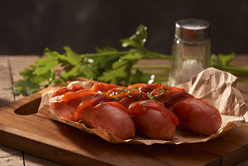 Grilled sausages with sauce ketchup on a wooden table