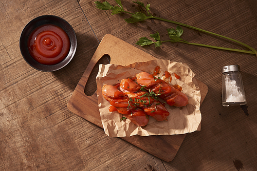 Grilled sausages with sauce ketchup on a wooden table