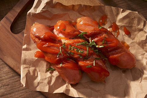 Grilled sausages with sauce ketchup on a wooden table