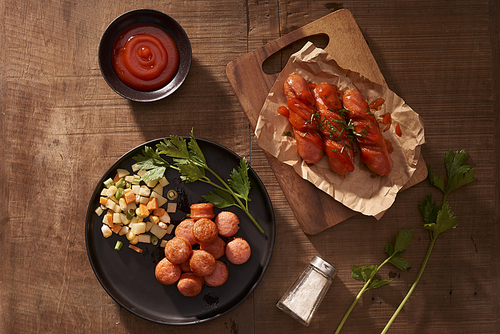 Grilled sausages with sauce ketchup on a wooden table