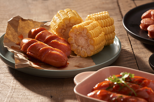 Grilled sausages with sauce ketchup on a wooden table