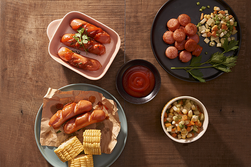 Grilled sausages with sauce ketchup on a wooden table