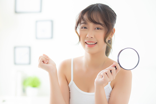 Beautiful young asian woman happy with magnifying skin of acne, beauty asia girl smiling check skincare of face, female analyzing trouble, cosmetic and makeup, health care and wellness concept.