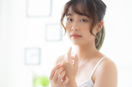 Beautiful young asian woman applying cream and treatment for skin care touch on hand, asia girl with lotion spa and moisturizing for health and wellness body part, lifestyle and beauty cosmetic concept.