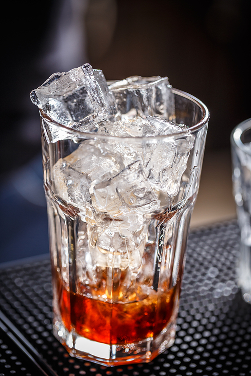 Glass with ice cubes on the bar counter