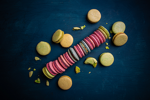 Sweet and colorful French macarons on blue background