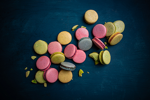Colorful macarons dessert on blue background, top view
