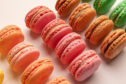 Small French cakes in different colours on light background