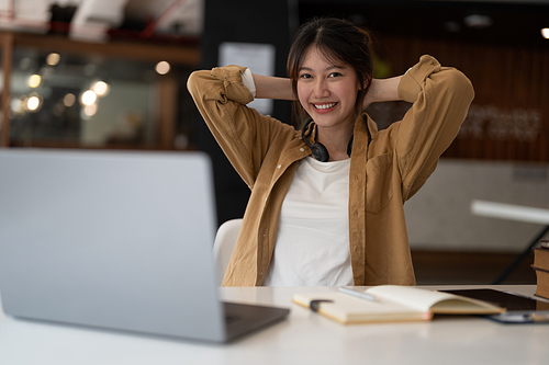 Portrait of young asian woman using laptop and writing making list taking notes in notepad working or learning on laptop indoors- educational course or training, seminar, education online concept