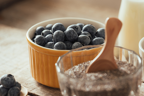 Fresh blueberries, almond and chia seeds with milk on wooden board. Ideal healthy breakfast concept.