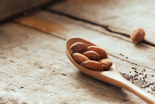 Almonds pour from wood spoon