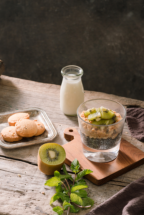 Healthy breakfast - bowl of muesli, berries and fruit, nuts, kiwi, milk