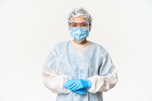 Portrait of asian doctor or nurse in ppe, personal protective equipment, standing in confident, ready pose, white background.