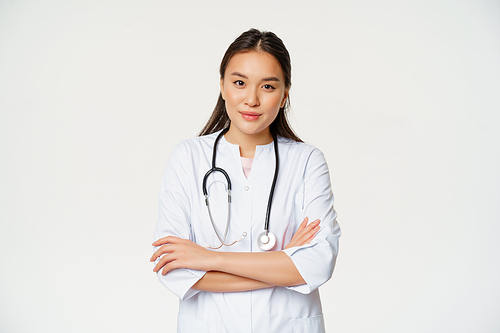 Portrait of asian doctor woman, cross arms, standing in medical uniform and stethoscope, smiling at camera, white background.