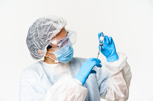 Portrait of asian woman doctor, nurse vaccinating patients, using syringe and covid-19 vaccine, standing in personal protective equipment, white background.