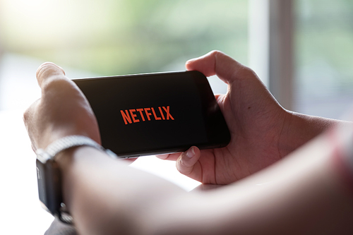 CHIANG MAI, THAILAND, NOV 17, 2019: Woman hand holding Smart Phone with Netflix logo on Apple iPhone Xs. Netflix is a global provider of streaming movies and TV series.