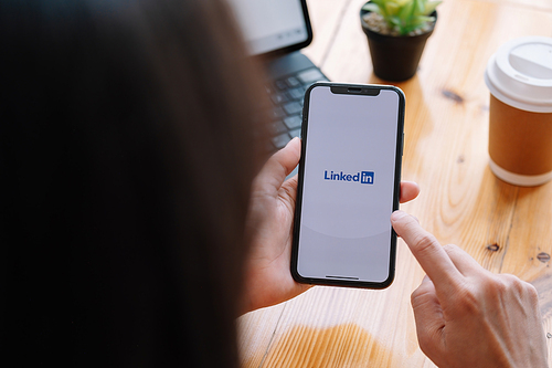 CHIANG MAI, THAILAND, MAR 21, 2021 : A women holds Apple iPhone Xs with LinkedIn application on the screen.LinkedIn is a photo-sharing app for smartphones.