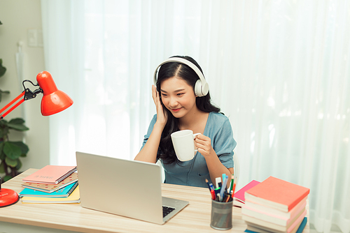 Smart asian  girl desk work remote laptop watch seminar drink beverage mug in house indoors