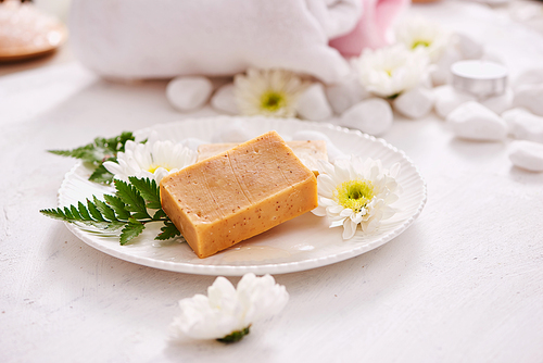 beauty, spa, body care, bath and natural cosmetics concept - close up of handmade soap bars on white table