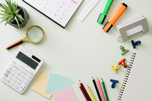 Business concept: stapler,markers, magnifier, cutter, tape, pen, pencil, clip, calculator, calendar and color pencil