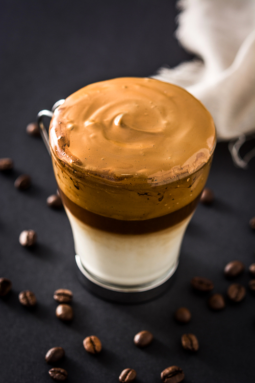 Creamy iced dalgona coffee on black background