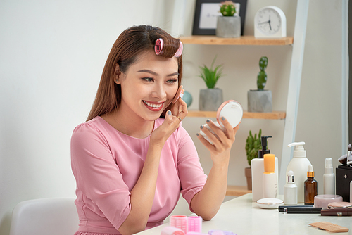 Close up portrait of charming pretty cute good-looking stylish trendy fashionable sexy applying powder with sponge on cheeks looking in mirror in morning