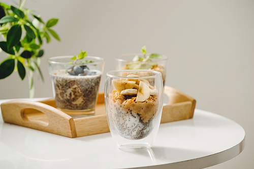 Fruits yogurt parfait with granola and chia seeds for healthy breakfast on wooden table