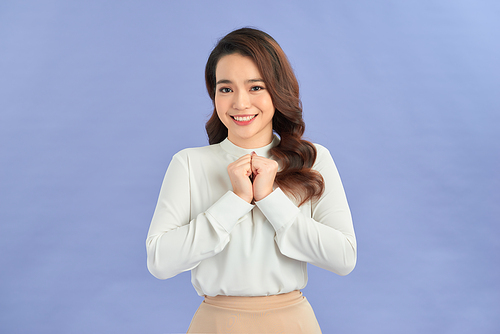 Photo of happy young woman isolated over purple background. Looking camera showing winner gesture.