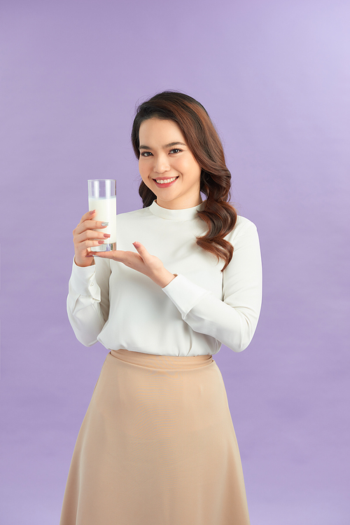 young woman drinking milk, isolated on purple background
