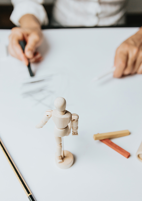 High angle view of a senior Caucasian woman drawing sketches in studio. Creativity, education and people concept,cognitive functions clock drawing self assessment test at home with positive results