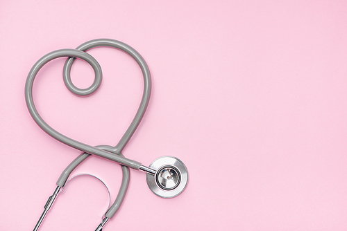 Medical concept. The stethoscope with heart shape on pink background.