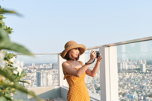 Asian Woman taking a photo using professional camera. Young photographer, natural light.