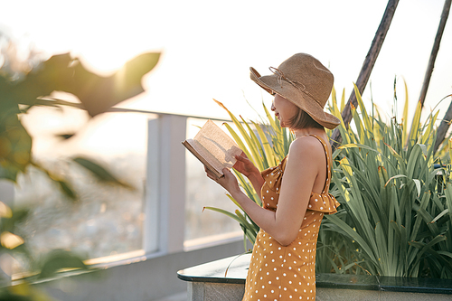 Portrait of young Asian girl is reading book in roof top of building.