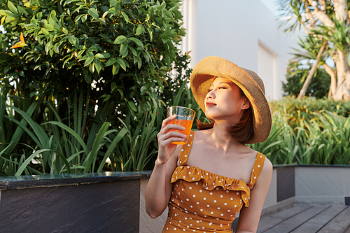 Attractive asian woman relaxing and drinking in the park