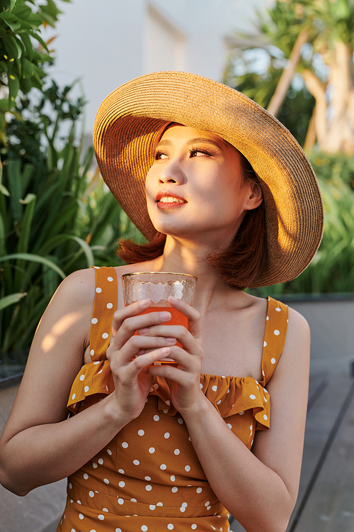 Attractive asian woman relaxing and drinking in the park