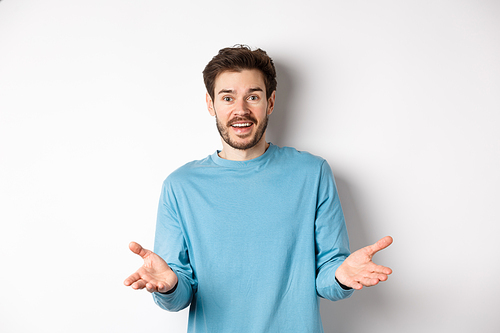 Handsome young man feeling happy for you, pointing hands at camera and praising good work, congratulations gesture, standing over white background.