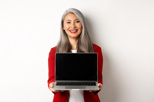 Business. Smiling asian businesswoman showing blank digital tablet screen, standing over white background.