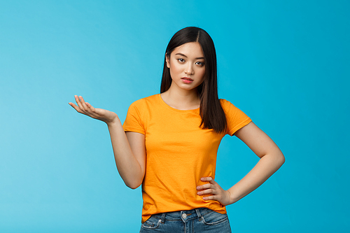 Ignorant bossy asian woman high-standarts, look dismay arrogant, act snobbish complaining bad service, raise hand full disbelief, cannot stand nonsense, stand annoyed blue background.