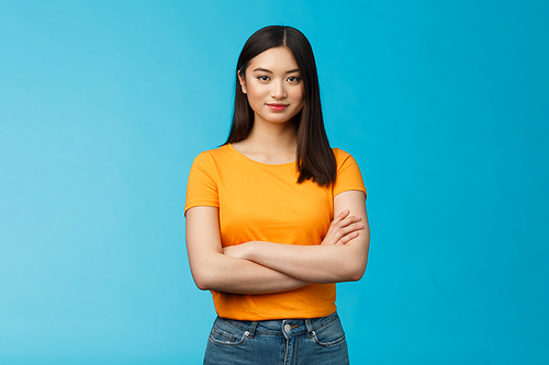 Confident motivated feminine asian woman feel empowered deal office problems manage business, hold hands crossed chest, smiling determined, wear yellow t-shirt, stand blue background.