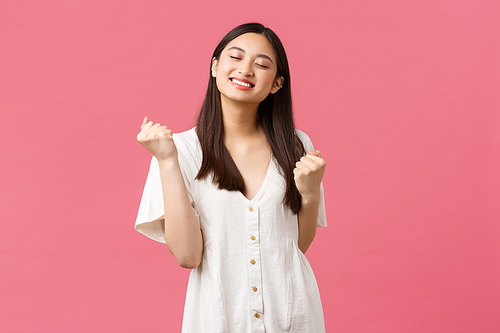 Beauty, people emotions and summer leisure concept. Satisfied happy and relieved asian cute girl feel taste of success, clench hands saying yes and smiling with closed eyes, triumphing.