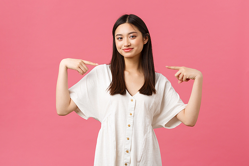 Beauty, people emotions and summer leisure and vacation concept. Confident stylish asian girl in white dress, smiling satisfied and pointing at herself proud, show-off, standing pink background.