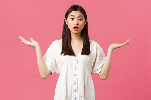 Beauty, people emotions and summer leisure concept. Troubled and confused asian girl in white dress standing clueless, need help, shrugging with hands spread sideways and nervous look.