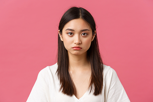 Beauty, people emotions and summer leisure concept. Close-up of gloomy and sad, tired young asian female employee looking at camera reluctant, standing distressed over pink background.