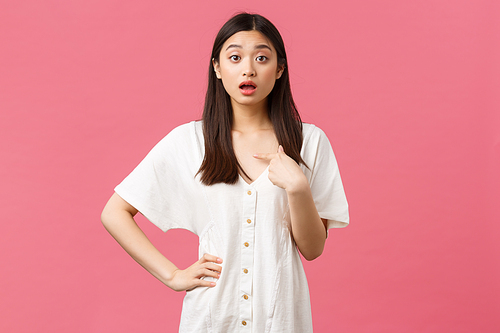 Beauty, people emotions and summer leisure and vacation concept. Surprised and astounded cute silly asian girl was chosen, pointing at herself puzzled, standing pink background.