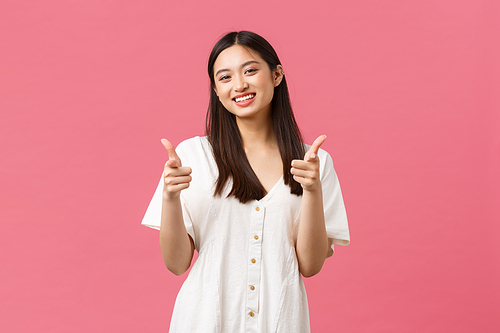 Beauty, people emotions and summer leisure and vacation concept. Cheerful silly korean girl in white dress, showing thumbs-up and smiling, smiling pleased, satisfied with product, recommend it.