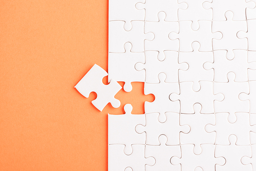 Top view flat lay of paper plain white jigsaw puzzle game texture last pieces for solve and place, studio shot on an orange background, quiz calculation concept