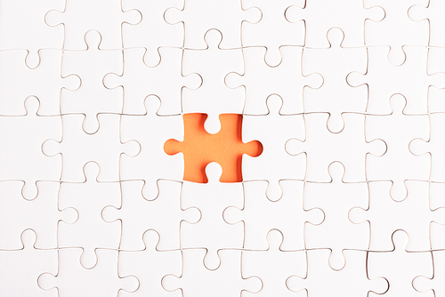 Top view flat lay of paper plain white jigsaw puzzle game texture incomplete or missing piece, studio shot on an orange background, quiz calculation concept