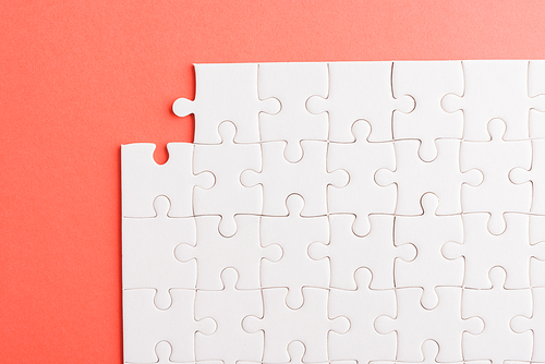 Top view flat lay of paper plain white jigsaw puzzle game texture last pieces for solve and place, studio shot on a red background, quiz calculation concept